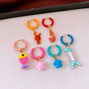 Macro view of ocean series enamel earrings including lobster and fish bone charms
