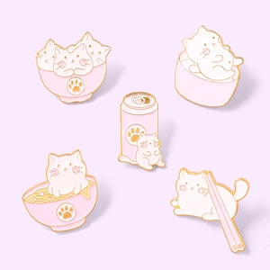 Gros plan détaillé de cinq pin's chat en émail rose et blanc avec contours en métal doré