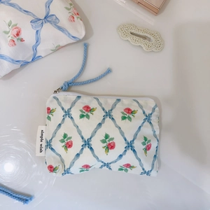 Detailed macro view of cotton coin purse with blue ribbon lattice and pink floral patterns