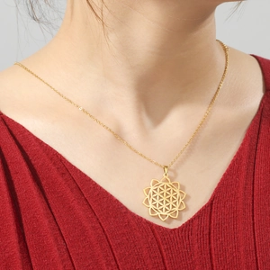 Close-up of golden stainless steel mandala pendant necklace on model with red sweater