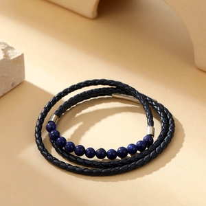 Detail of multi-layer black braided leather bracelet with deep blue stone beads