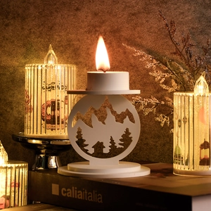 Dettaglio del portacandele bianco traforato con design di montagna e bosco al laser