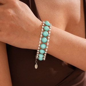 Close-up of bohemian silver bracelet with turquoise bead and white crystal diamonds