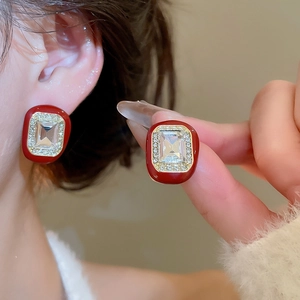 Detail view of red enamel geometric stud earrings with sparkling central zircon crystal