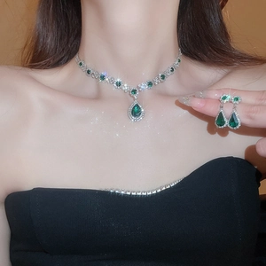 Elegant silver jewelry set with teardrop green gemstones and sparkling rhinestones