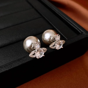 Elegant zircon planet earrings with pearls and silver studs shown on jewelry box