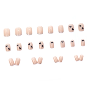 Short nude pink false nails with black heart patterns and silver glitter gradient effects