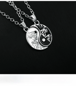 Macro shot of yin yang dragon pendants on polished silver chains with engraved details