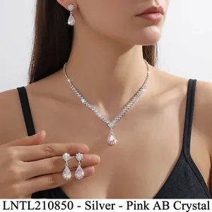 Detail of V-shaped crystal necklace and pear-cut pink AB teardrop earrings on model