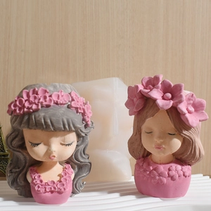 Close-up of resin flower girl statues with floral crowns in gray and brown tones