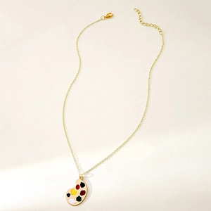 Detailed view of the gold palette pendant necklace with vibrant multi-color enamel dots