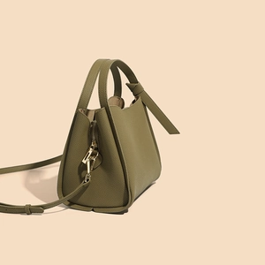 Green leather bucket bag with gold hardware shown from a side and bottom perspective