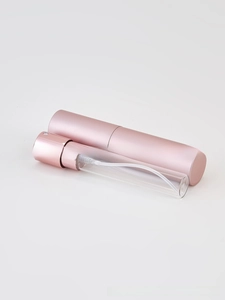 Disassembled view of portable perfume spray bottle with rose gold shell and glass inner core