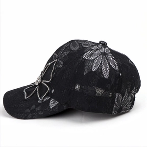 Close-up of black lace baseball cap featuring a sparkling rhinestone butterfly detail