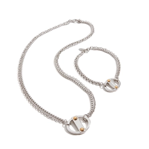 Detailed close-up of a silver stainless steel necklace and bracelet set with gold rivets
