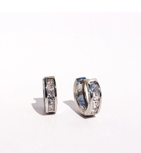 Macro shot of silver small hoop earrings featuring sparkling clear cubic zirconia stones