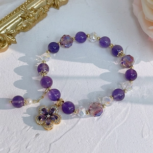 Detailed shot of amethyst bracelet with zircon flower pendant and pearl charm