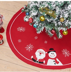 Détail du tapis de sapin de Noël tricoté rouge avec motifs Père Noël et flocons de neige
