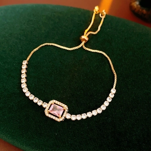 Close-up of adjustable gold-plated bracelet with pink rectangular stone and pavé zircon
