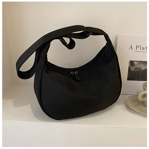 Detail of black oxford nylon crescent bag with adjustable wide strap and dual zippers