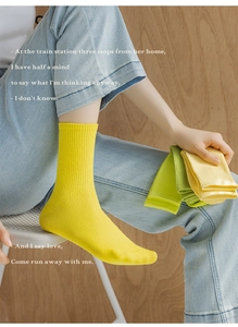 Detail of yellow ribbed cotton crew socks showing high elasticity and soft texture