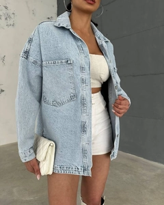 Detail of oversized retro denim jacket showing large patch pockets and loose fit texture