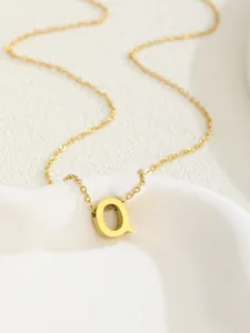 Close-up of gold plated stainless steel necklace featuring a minimalist letter Q pendant