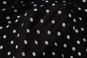 Detailed macro view of lightweight black polka dot fabric with semi-transparent texture