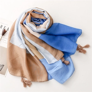 Detail of soft color-block scarf with woven tassels and elegant fringe texture