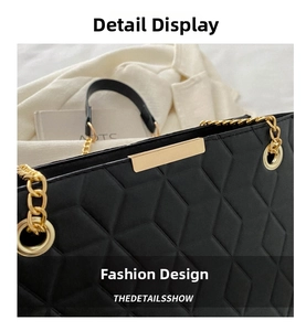 Close-up of black quilted tote bag with gold chain strap and metal hardware detail