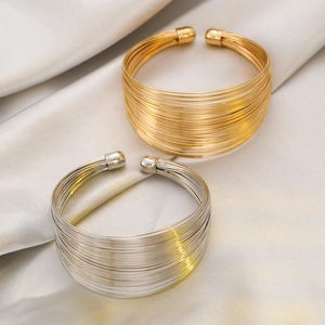 Fashionable layered multi-line open cuff bracelets in polished gold and silver finishes