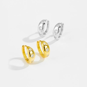 Detail of gold and silver S925 sterling silver hoop earrings with three star-set zircons