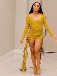 Détail de la robe en dentelle jaune gingembre avec décolleté à volants et motifs ajourés