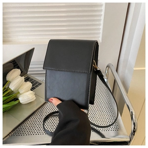Vue détaillée du petit sac à bandoulière noir minimaliste en similicuir poli et brillant