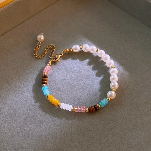 Detail of colorful beads and freshwater pearls bracelet with gold extension chain clasp