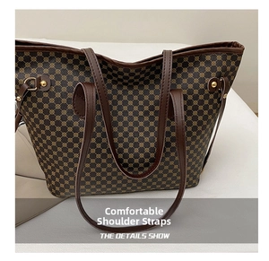 Detail of vintage printed tote bag showing durable leather straps and gold rivets