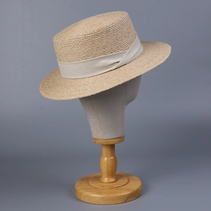 Vue détaillée du chapeau canotier en raphia avec ruban élégant en tissu crème