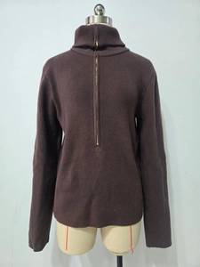 Detail of dark brown ribbed knit sweater featuring a functional half-zip high collar design