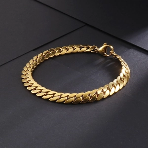 Macro view of golden Cuban link chain bracelet on dark grey geometric background