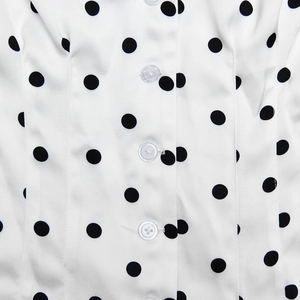 Close-up of white polka dot fabric texture with small buttons and neat stitching