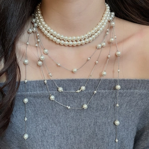 Detail of layered pearl necklace with silver chains and elegant fringe tassels on model