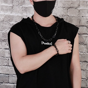 Close-up of black paperclip chain necklace and bracelet set worn by a male model
