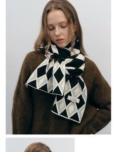 Detailed view of black and white diamond knit scarf with an authentic design brand label