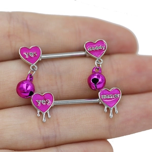 Dettaglio del piercing capezzolo a cuore con campanellino viola e ciondoli incisi