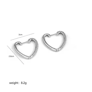 Macro detail of heart-shaped twist earrings with pave zircon and silver polished finish