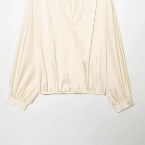 Blouse élégante en satin beige à manches longues, col en V, design croisé et aspect soyeux
