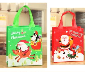 Detail of red and green Christmas non-woven gift bags with festive prints and handles