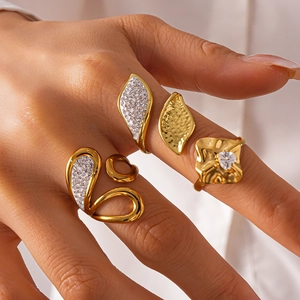 Close-up of gold leaf-shaped rings with pave-set diamonds and hammered texture