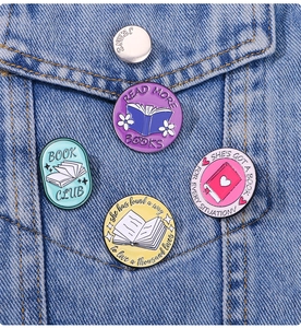 Detail of four colorful enamel book pins attached to a classic blue denim jacket pocket