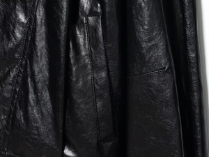 Detail shot of black faux leather texture with fine stitching and side pocket design